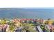 Aerial view of waterfront condo with private beach access, lush landscaping, and nearby covered parking at 7520 Sunshine Skyway S Ln # 210, St Petersburg, FL 33711