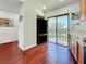 Modern kitchen area with wood floors, black refrigerator, and access to the balcony at 7520 Sunshine Skyway S Ln # 210, St Petersburg, FL 33711