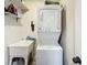 Compact laundry area with stacked washer and dryer unit, and utility sink at 7520 Sunshine Skyway S Ln # 210, St Petersburg, FL 33711