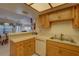 Kitchen with ample wood cabinetry, a double sink, and views into the dining area at 1106 Lennox W Rd, Palm Harbor, FL 34683