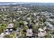 Aerial view of a community with houses and lush green trees at 1106 Lennox W Rd, Palm Harbor, FL 34683