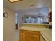 Open kitchen with light countertops, wood cabinets, and a view of the dining and living area at 1106 Lennox W Rd, Palm Harbor, FL 34683