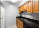 Kitchen with wood cabinets, granite counters, and stainless steel sink at 14323 Hanging Moss Cir # 102, Tampa, FL 33613