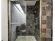 Walk-in shower with dark tile and glass enclosure at 36750 Us Highway 19 N # 04208, Palm Harbor, FL 34684