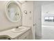 Small bathroom with a vanity, sink, and a large round mirror at 36750 Us Highway 19 N # 04208, Palm Harbor, FL 34684