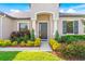 House entrance with dark-colored door, white columns, and colorful landscaping at 913 Buckhurst Dr, Spring Hill, FL 34609
