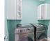Bright laundry room with modern washer and dryer, and upper cabinets at 913 Buckhurst Dr, Spring Hill, FL 34609