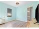 Light blue bedroom with wood-look floors and TV at 913 Buckhurst Dr, Spring Hill, FL 34609