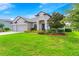Two-story house with three-car garage, manicured lawn, and mature trees at 913 Buckhurst Dr, Spring Hill, FL 34609