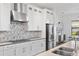 Modern kitchen with stainless steel appliances and gray chevron backsplash at 913 Buckhurst Dr, Spring Hill, FL 34609