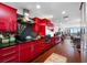 Bright red kitchen with hardwood floors and view into living room at 1 Beach Se Dr # 2007, St Petersburg, FL 33701