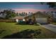 House exterior at dusk, featuring a stone facade and a two-car garage at 17615 Willow Creek Blvd, Lutz, FL 33549