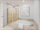 Bathroom featuring a soaking tub and glass shower with neutral color palette at 450 Knights Run Ave # 1607, Tampa, FL 33602