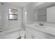 Renovated bathroom with white vanity, marble tile, and bathtub at 6185 Alderwood St, Spring Hill, FL 34606