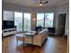 Bright living room with hardwood floors, white sofa, and large windows overlooking the city at 1209 E Cumberland Ave # 508, Tampa, FL 33602