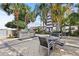 Outdoor patio area with stainless steel BBQ grill and seating surrounded by mature trees and lush landscaping at 1209 E Cumberland Ave # 508, Tampa, FL 33602