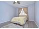 Cozy bedroom featuring light blue walls, a comfortable bed, and a large window with natural light at 15501 Pepper Pine Ct, Land O Lakes, FL 34638