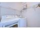 Laundry room with white washer and dryer, ample shelving, and bright lighting at 15501 Pepper Pine Ct, Land O Lakes, FL 34638