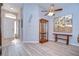 Bright living room features light wood flooring, a ceiling fan, and a stylish wooden display cabinet and matching bench at 15501 Pepper Pine Ct, Land O Lakes, FL 34638