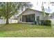 Backyard view of home with screened patio and green grass at 15501 Pepper Pine Ct, Land O Lakes, FL 34638