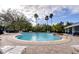 Kidney shaped community pool with lounge chairs and landscaping at 15501 Pepper Pine Ct, Land O Lakes, FL 34638