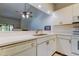 Bright kitchen with ample counter space, white cabinets, and a breakfast bar at 1401 Powderpuff Dr # 102, Dunedin, FL 34698