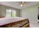 Main bedroom with a full-size bed, ceiling fan and sliding glass door to backyard at 1401 Powderpuff Dr # 102, Dunedin, FL 34698