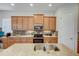 Modern kitchen with a granite island, stainless appliances, and tile backsplash, enhanced by tile floors at 1804 Pacific Dunes Dr, Sun City Center, FL 33573