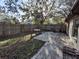 Small backyard with patio, wooden fence, and partial view of house at 2672 Arjay Ct, Palm Harbor, FL 34684