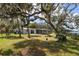Spacious backyard showcasing a home with river views and a large oak tree at 505 S 56Th St, Tampa, FL 33619