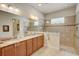 Spa-like bathroom with dual sinks, granite counters, and walk-in shower at 1804 Pacific Dunes Dr, Sun City Center, FL 33573
