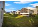 Screened porch and grassy backyard with homes in the background at 6703 Pistachio St, Zephyrhills, FL 33542