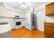 Bright kitchen boasts white cabinetry, wood flooring, and a modern refrigerator at 6703 Pistachio St, Zephyrhills, FL 33542