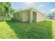 Tan house exterior with covered patio and grassy yard at 2010 1/2 E Wood St # St, Tampa, FL 33604