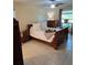 Cozy bedroom with a wooden bed, tile flooring, a ceiling fan, and natural light from the window at 2390 Shelly Dr # D, Palm Harbor, FL 34684