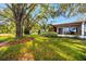 Spacious front yard with large trees providing shade, manicured lawn, and tasteful landscaping enhancing curb appeal at 2390 Shelly Dr # D, Palm Harbor, FL 34684