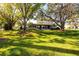 Well-manicured front lawn with mature trees shading the property, complemented by neat landscaping for inviting curb appeal at 2390 Shelly Dr # D, Palm Harbor, FL 34684