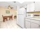 Bright kitchen features white appliances, tile flooring and a cozy dining area at 2390 Shelly Dr # D, Palm Harbor, FL 34684