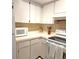 Bright kitchen featuring white cabinets, countertops, and appliances, complemented by a stylish backsplash at 2390 Shelly Dr # D, Palm Harbor, FL 34684