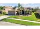 Charming gray home featuring manicured lawn, two-car garage, and well-maintained landscaping at 4538 Pointe O Woods Dr, Wesley Chapel, FL 33543