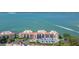 A view of the condo building with parking spaces and a water view in the background at 5825 Puerta Del Sol S Blvd # 170, St Petersburg, FL 33715