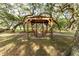 Wooden gazebo with double swing under large oak trees at 37338 Sandra Ave, Zephyrhills, FL 33542