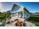 Quaint light blue house with a front porch and manicured lawn at 509 W Cedar St, Tarpon Springs, FL 34689