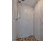 Clean shower with marble-like tile and pebble floor at 6614 10Th Avenue S Ter, St Petersburg, FL 33707