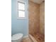 Bathroom with light blue walls, tile shower, and toilet at 6614 10Th Avenue S Ter, St Petersburg, FL 33707