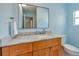 Bathroom with light blue walls, marble countertop, and wood cabinets at 6614 10Th Avenue S Ter, St Petersburg, FL 33707