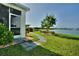 Lush backyard with a stone path leading to the lake, enhanced by vibrant landscaping at 1027 Ocean Spray Dr, Ruskin, FL 33570