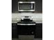 Modern kitchen with stainless steel appliances and dark cabinetry for a sleek design at 1027 Ocean Spray Dr, Ruskin, FL 33570