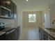 Modern kitchen with dark cabinetry, granite countertops, and dining area at 1027 Ocean Spray Dr, Ruskin, FL 33570