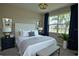 Beautiful staged bedroom featuring stylish lamps, blue accent colors, and a bright window at 1027 Ocean Spray Dr, Ruskin, FL 33570